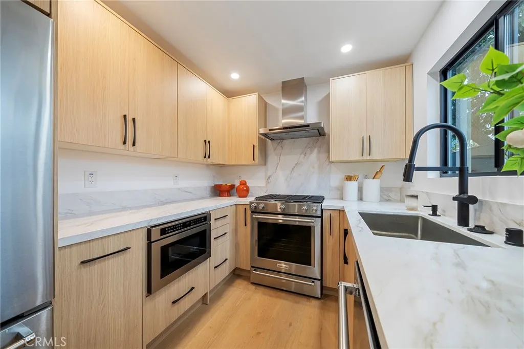 2225 Shoredale gorgeous galley kitchen with quartz counters and appliances to remain: refrigerator, cabinet drawer microwave, dishwasher, gas stove.