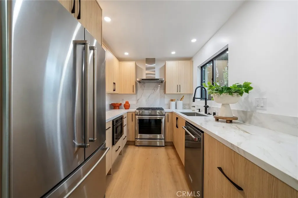 2225 Shoredale gorgeous galley kitchen with quartz counters and appliances to remain: refrigerator, cabinet drawer microwave, dishwasher, gas stove.