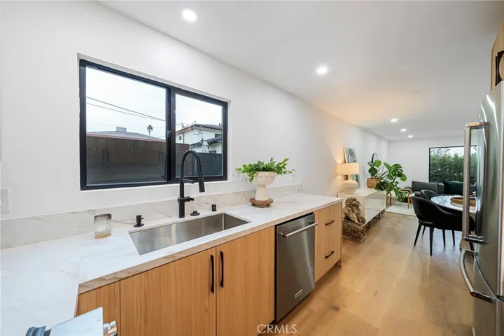 2225 Shoredale gorgeous galley kitchen with quartz counters and appliances to remain: refrigerator, cabinet drawer microwave, dishwasher, gas stove.