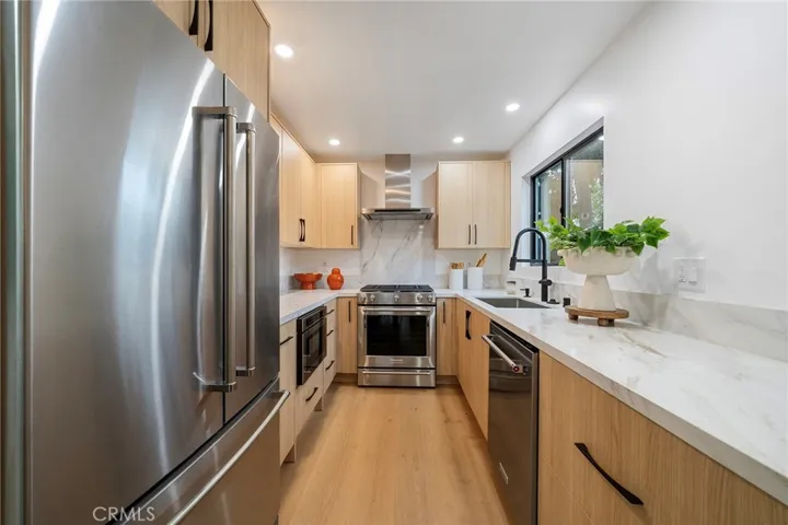 2225 Shoredale gorgeous galley kitchen with quartz counters and appliances to remain: refrigerator, cabinet drawer microwave, dishwasher, gas stove.