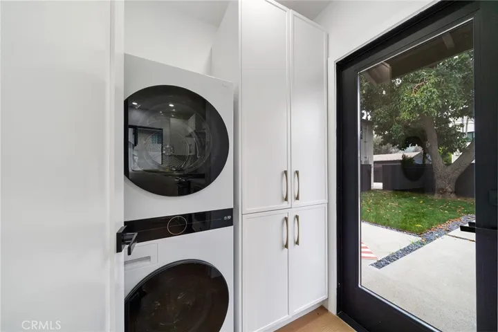2229 Shoredale Stackable laundry with natural light from the exterior glass door.