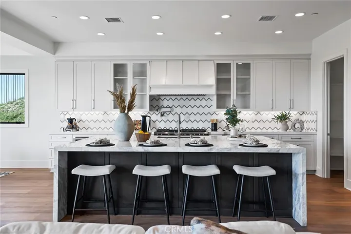 Gourmet kitchen with two tone cabinets, waterfall island