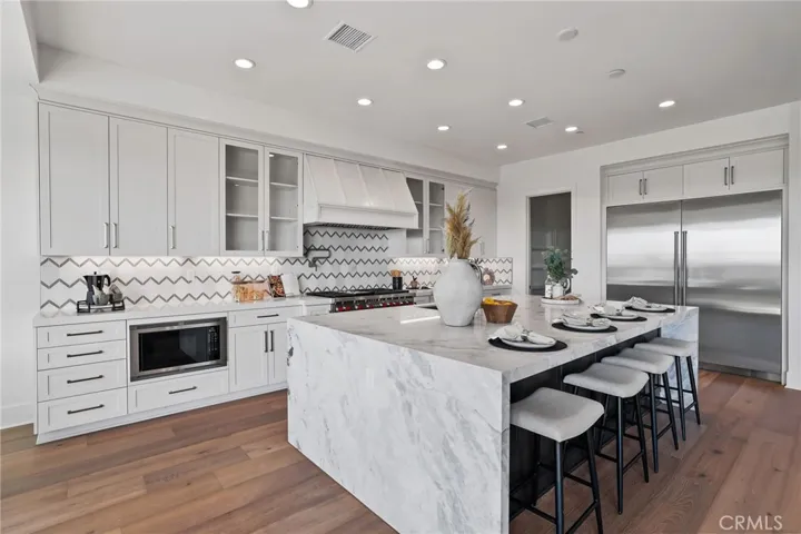 Gourmet kitchen with two tone cabinets, waterfall island