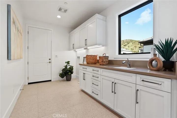 Huge laundry with sink and secondary walk-in closet/pantry