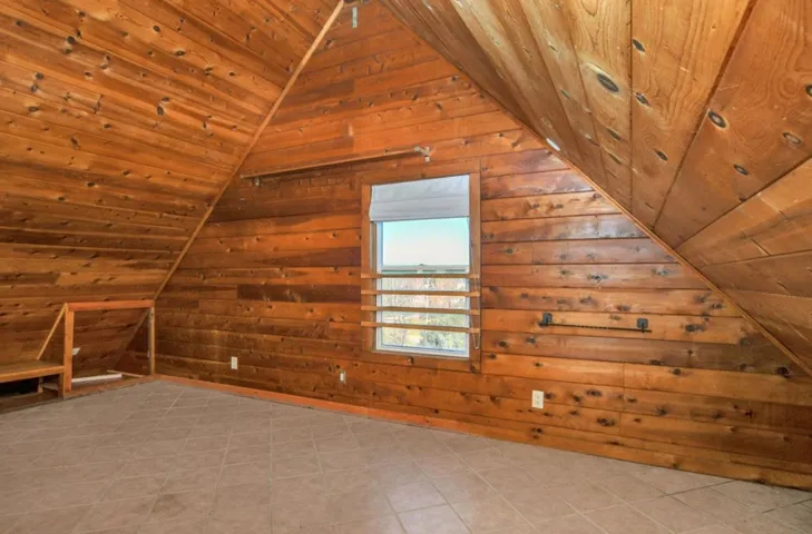 Additional living space featuring wood ceiling, lofted ceiling, and wood walls