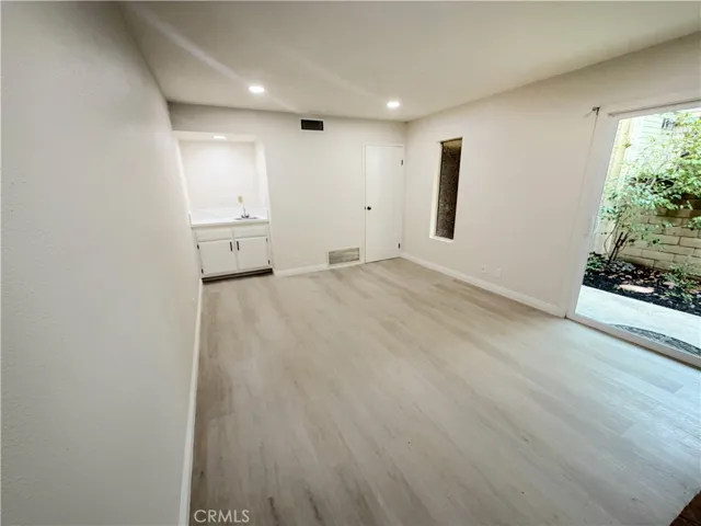 Den with view of wet bar/sink and sliding door
