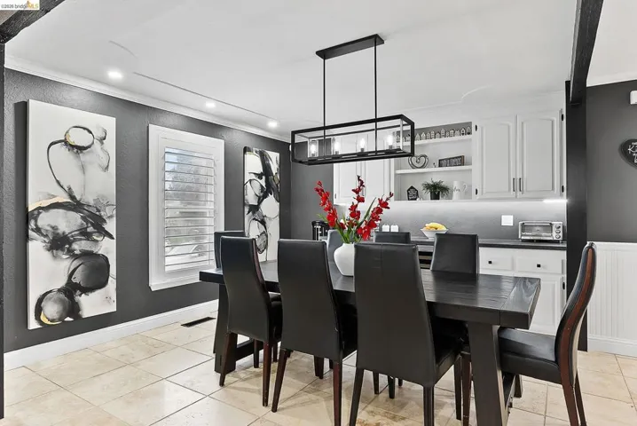 Dining space featuring ornamental molding, light tile patterned flooring, recessed lighting, and a textured wall