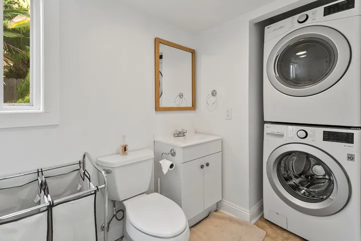 Half bath at rear of home with laundry setup.