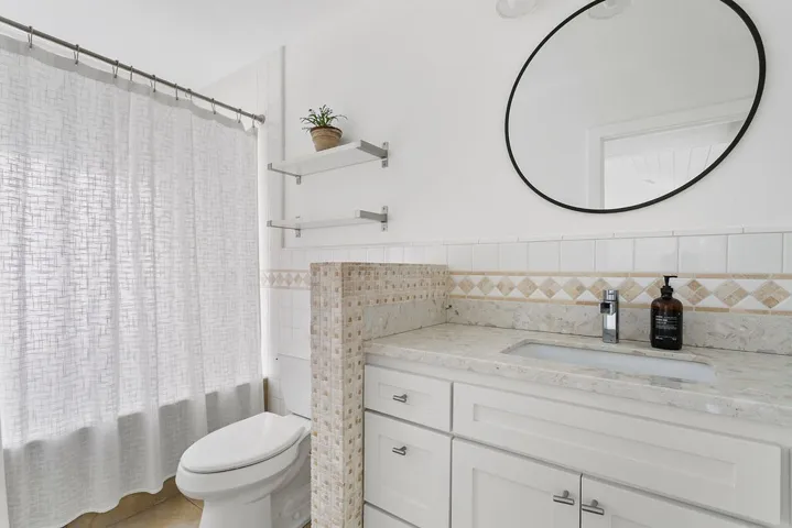 Primary bathroom with shower over tub.