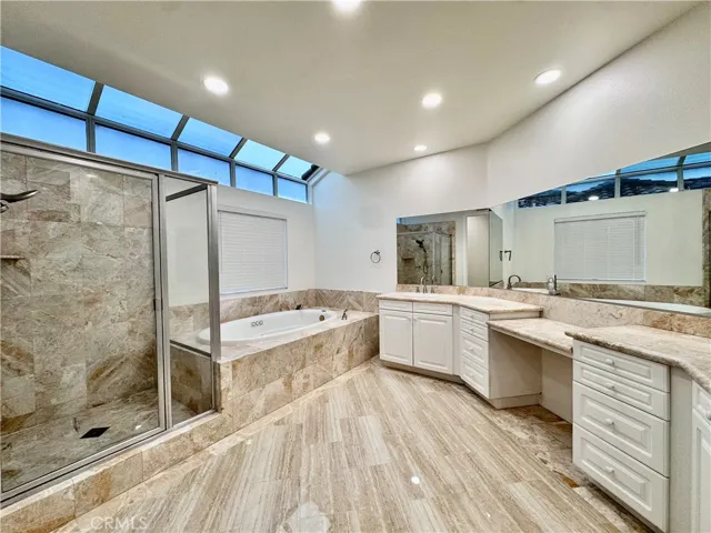 Main bathroom with dual vanities, jetted tub, and separate shower