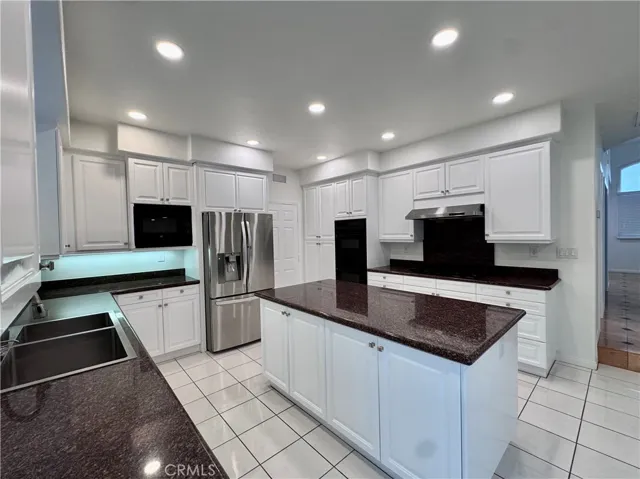 Kitchen with cooktop and refrigerator