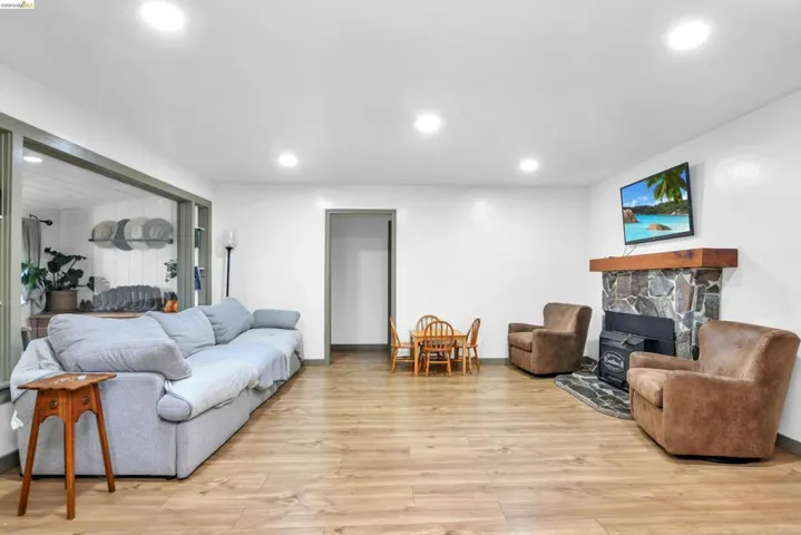 Living area featuring a stone fireplace, light wood finished floors, and recessed lighting