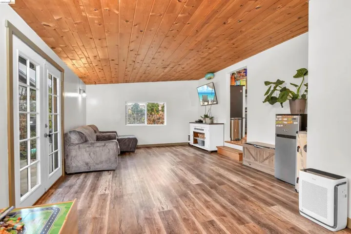 Living area featuring wooden ceiling, light wood-style flooring, and french doors