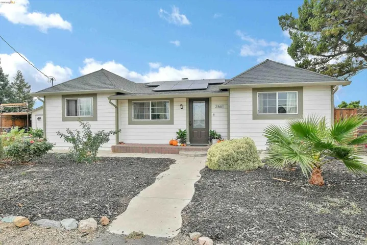 Ranch-style house featuring roof with shingles and roof mounted solar panels