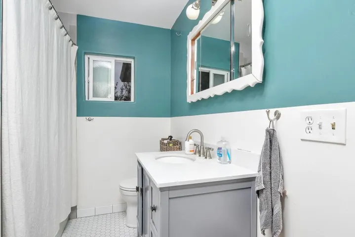 Bathroom with a shower with shower curtain, vanity, and light tile patterned floors