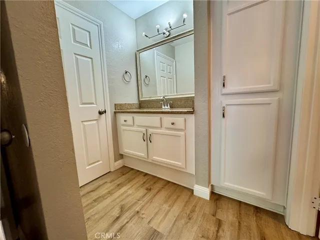 Private vanity/sink and linen in primary bedroom