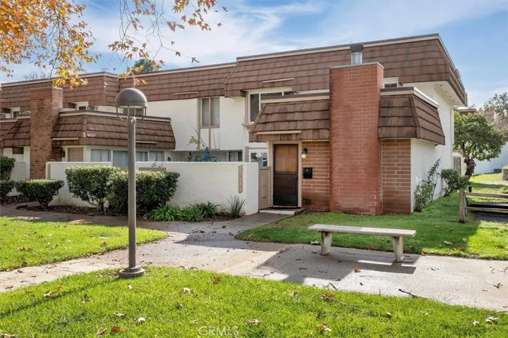 Charming brick and stucco façade with mature landscaping and an inviting entry.