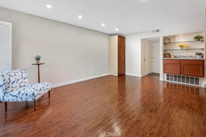 Spacious family room with beautiful wood flooring and recessed lighting and open to spacious patio.