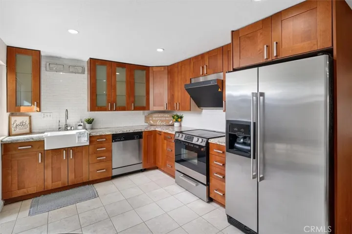 Chef-friendly kitchen with granite countertops, classic farmhouse sink and sleek backsplash.