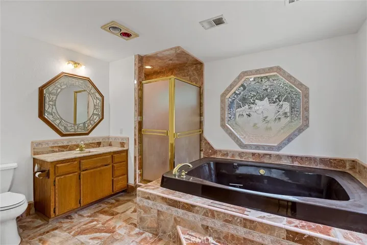 Primary bath with jetted tub and walk-in shower, complete with marble accents!