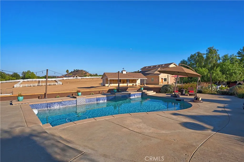 Saltwater pool features waterfalls, swim step and market lighting