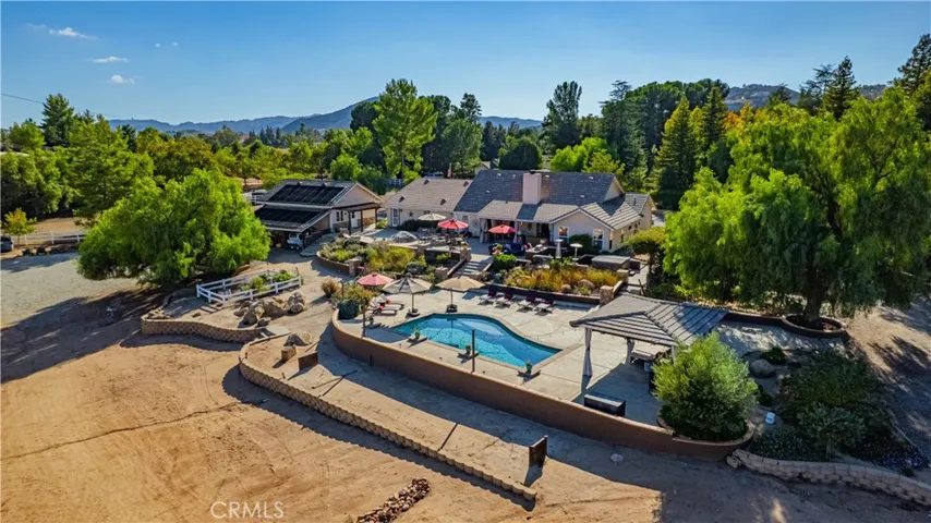Entertaining area on rear of main home - showcasing cabana area, garden, horse shoe pit and lush landscaping