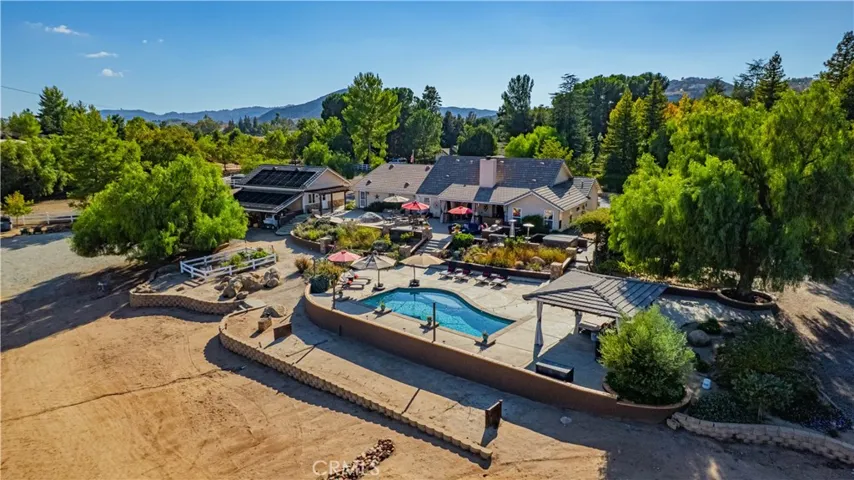 Entertaining area on rear of main home - showcasing cabana area, garden, horse shoe pit and lush landscaping