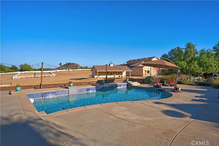Saltwater pool features waterfalls, swim step and market lighting