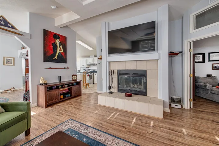 Stunning living room with wood laminate floors, raised hearth tile fireplace and coffered ceiling.