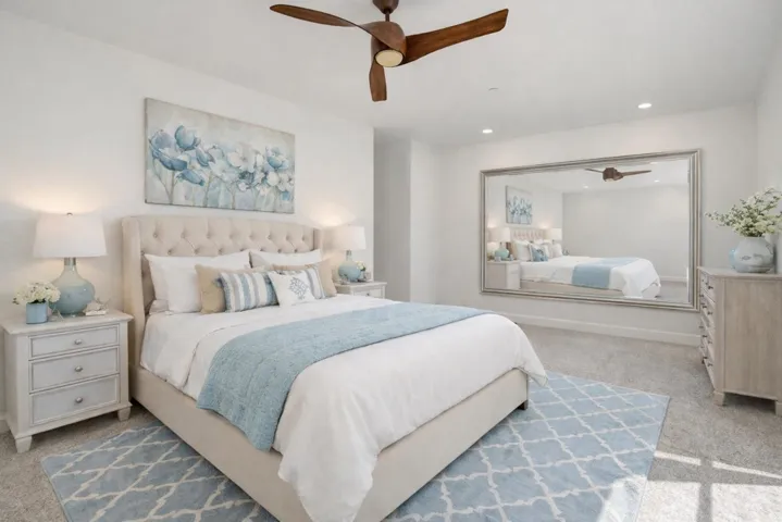Carpeted bedroom featuring ceiling fan and recessed lighting