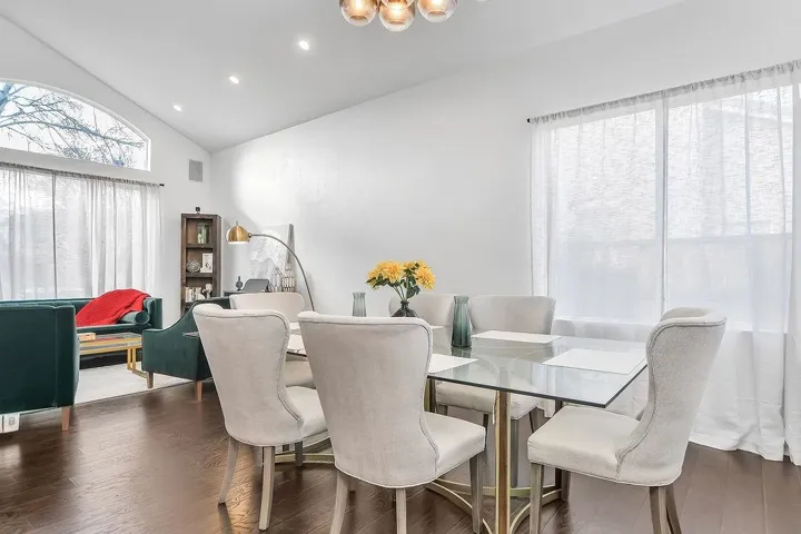 Dining space featuring dark wood-type flooring, lofted ceiling, and recessed lighting