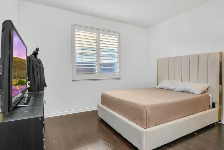 Bedroom featuring dark wood finished floors and baseboards
