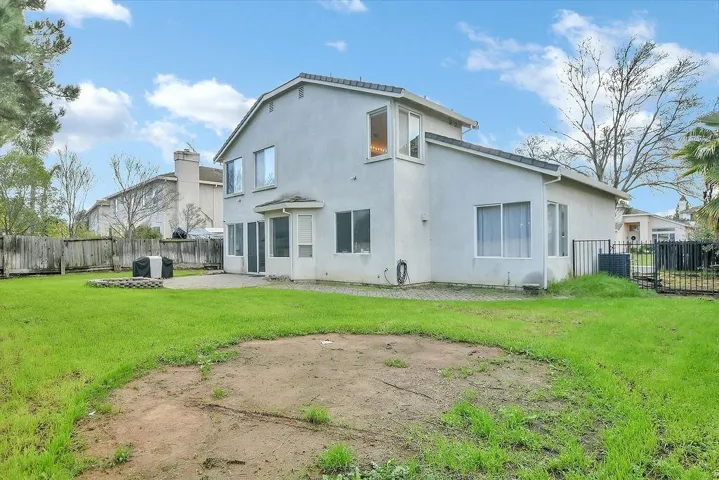 Rear view of house with a fenced backyard, a patio area, and stucco siding
