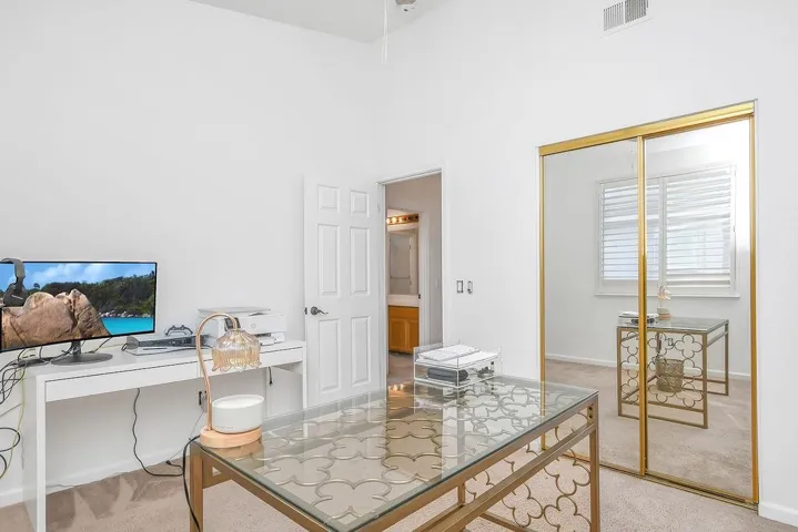 Office with light colored carpet and a towering ceiling