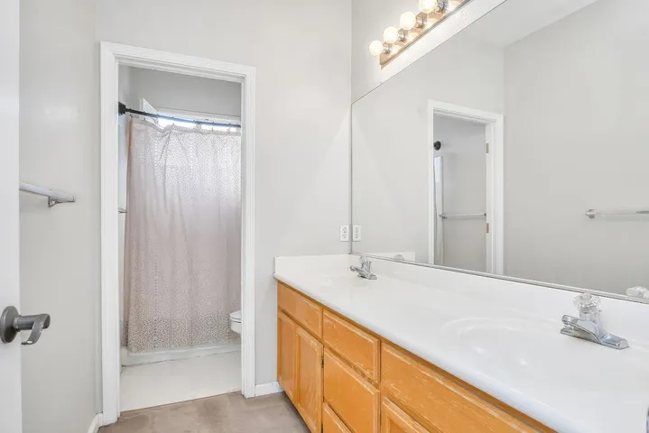 Full bathroom featuring double vanity and toilet