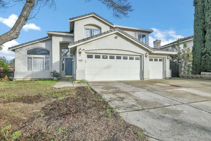 View of front of property featuring concrete driveway, stucco siding, and an attached garage