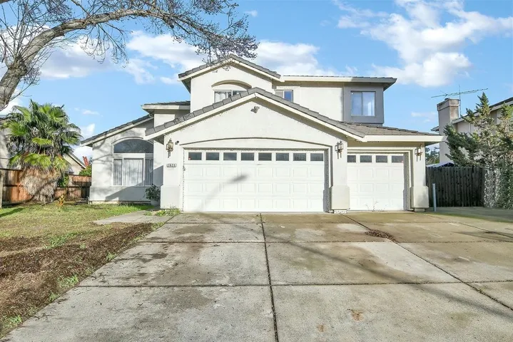 View of front of home with driveway, stucco siding, and a garage