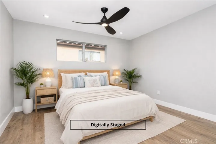 Digitally staged primary bedroom featuring modern ceiling fan, wide-plank flooring, and a spacious, relaxing layout.