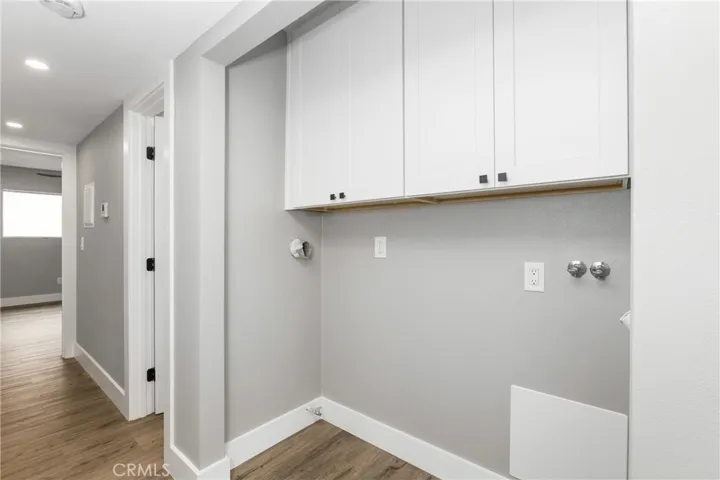 Dedicated laundry space with hookups for full-size washer and dryer and additional storage above.