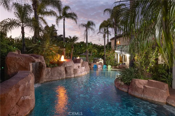 Winding pool, spa and grotto surrounded by lush landscaping