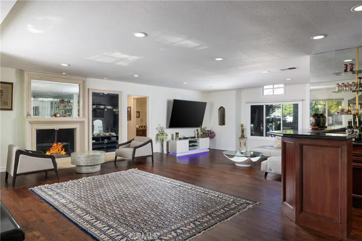 Generous family room space with private bar and cozy fireplace