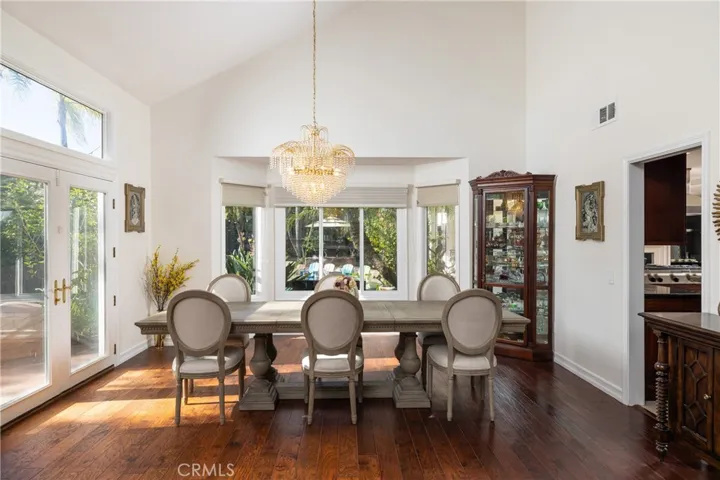 Formal dining room with high ceilings, French doors and pool views.