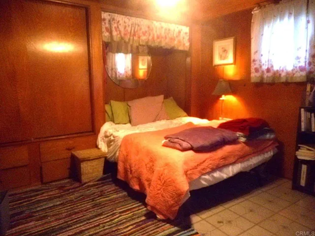 Bedroom has gleaming wood walls. 2 closets and lots of storage