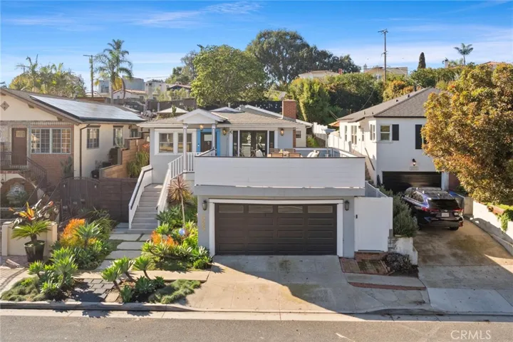 Aerial view of the home from the street. Garage access from the street and a patio on top