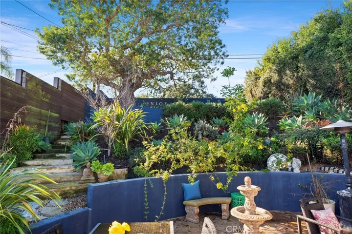 A serene garden separates the levels of entertainment spaces in this backyard.