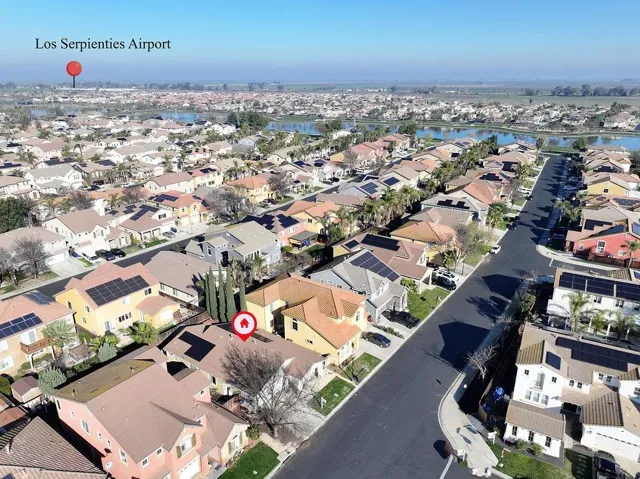 Aerial view of property and surrounding area with a large body of water and nearby suburban area