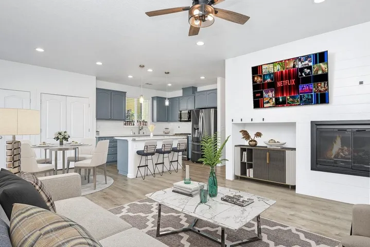 Living area featuring light wood finished floors, ceiling fan, recessed lighting, and a glass covered fireplace