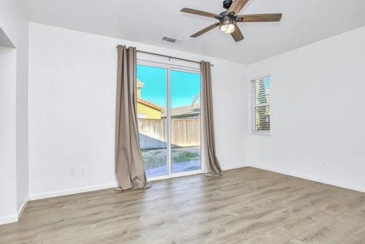 Empty room with light wood-style flooring and a ceiling fan