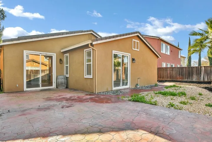 Back of property with stucco siding and a patio area