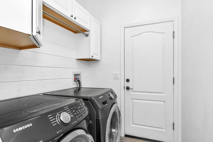 Laundry area featuring independent washer and dryer and cabinet space